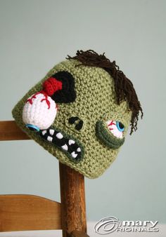 a crocheted zombie head sitting on top of a wooden chair