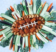 an arrangement of vegetables arranged in the shape of a football