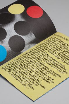 an open book with black, yellow and red dots on it