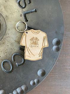 a keychain with a t - shirt on it sitting on top of a metal object