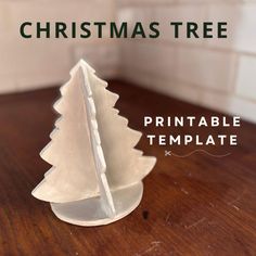 a paper christmas tree sitting on top of a wooden table