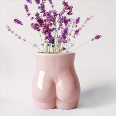 a pink vase with purple flowers in it