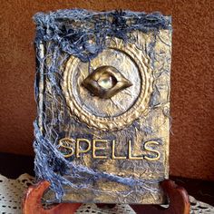 a book that is sitting on top of a wooden stand and has the word spells written in it