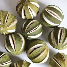 there are many green and white striped balls on the table, with one ball in the middle