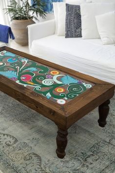 a coffee table sitting on top of a rug in a living room next to a couch