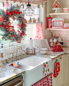 a kitchen decorated for christmas with red and white decor