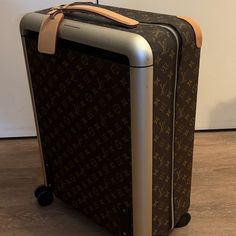 Louis Vuitton - Horizon 50 Monogram Spinner Suitcase Is A 20" Carry-On Soft Case Made Of Canvas Material. It Features A Retractable Handle, Wheels/Rolling, And Locking Mechanism. The Suitcase Is Tsa Approved And Has An Upright Design. It Is Designed For Women And Comes In Brown Color With The Louis Vuitton Monogram. Comes With Protective Nylon Suitcase Cover. Louis Vuitton Suitcase Brown Coated Canvas Lv Monogram Brass Hardware Leather Trim Flat Handles & Single Adjustable Shoulder Strap Leather Trim Embellishment Canvas Lining Zip Closure At Front Details Estimated Item Measurements Shoulder Strap Drop: 17.75" Handle Drop: 1.5" Height: 20" Width: 15.25" Depth: 9" Excellent Condition: Bou Louis Vuitton Suitcase, Suitcase Cover, Spinner Suitcase, Tsa Approved, Bags Louis Vuitton, Locking Mechanism, Lv Monogram, Brown Coat, Louis Vuitton Bags