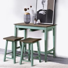 two stools and a table with a painting on the wall