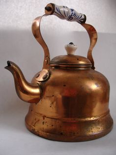 an antique brass tea kettle with a handle