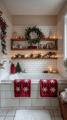 two red towels hanging on the side of a bathtub in a bathroom decorated for christmas