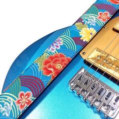 an electric guitar strap with flowers on it