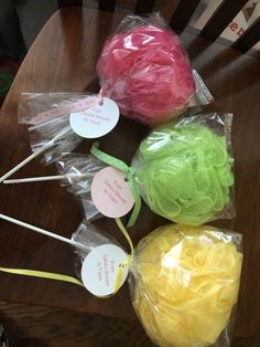 four lollipops wrapped in plastic bags on a table with tags attached to them