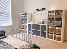 a baby's crib in the corner of a room with lots of storage