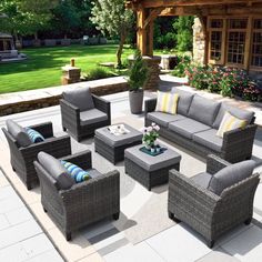 an outdoor patio with grey furniture and flowers