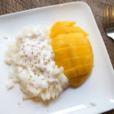 a white plate topped with rice and mango