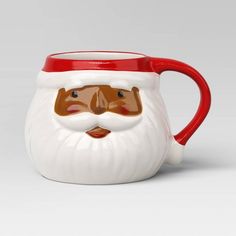 a red and white mug with a santa face on it