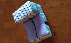 two wrapped gift boxes sitting on top of a wooden table next to each other with polka dots