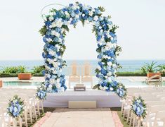 an outdoor ceremony setup with blue and white flowers