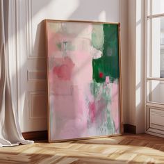 an abstract painting is displayed in the corner of a room with white walls and wooden floors