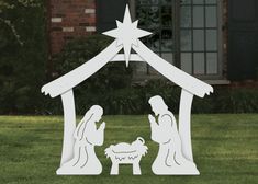 a nativity scene in the grass with a star above it and a manger