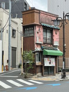 an old building with a green awning next to a street light on the corner