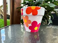 a flower pot sitting on top of a glass table