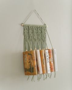 a wall hanging with books on it in the shape of a macrammean