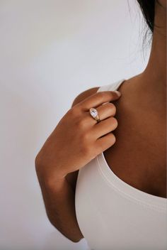 a woman's hand with a diamond ring on her shoulder