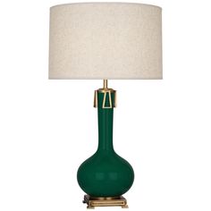 a green table lamp with a white shade on the top and gold trimmings