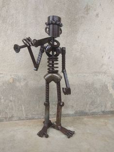 a metal skeleton holding a wrench on top of it's head and legs