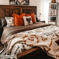 a bed with pillows and blankets on top of it in a bedroom next to a window