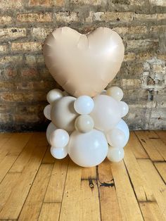 a heart shaped balloon sitting on top of a wooden floor