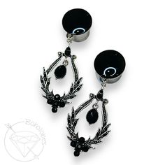 pair of black and white earrings with flower design on the front, hanging from an earring