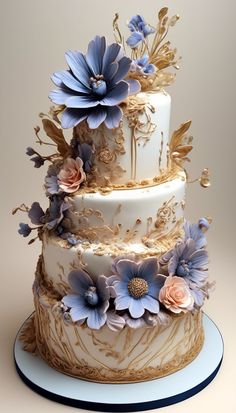 a three tiered cake with blue flowers and gold trimmings on a plate