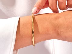 Crafted from the finest 14k gold, this bangle showcases a sleek, avant-garde geometric design. The clean lines and bold shapes make a powerful statement, turning your wrist into a canvas of modern sophistication. Wear it solo for a minimalist yet impactful look, or stack it with other bracelets to curate your unique style narrative.Features• Made to Order• Gold Kt: 14K• Gold Colors: Rose Gold, Yellow Gold, White Gold• Width: 3.70 mm• Thickness: 3.00 mm Adjustable Modern Bangle Tarnish Resistant, Modern Polished Bangle, Adjustable Tarnish-resistant Modern Bangle, Modern Adjustable Tarnish Resistant Bangle, Modern Adjustable Tarnish-resistant Bangle, Modern 14k Gold Bangle Bracelets, Modern Twist Bangle For Formal Occasions, Modern Gold Bangle With Polished Finish, Formal Bangle Bracelet With A Modern Twist