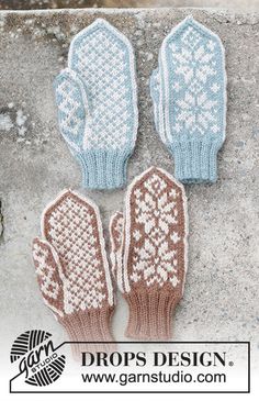 two knitted mittens sitting on top of a cement wall next to each other