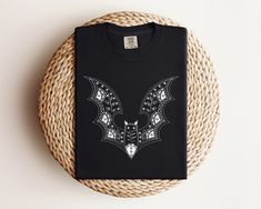 Intricate Bat Design Comfort Colors Halloween T-Shirt, Gothic Bat Graphic Tee, Halloween Bat Shirt, Spooky Bat Pattern, Unisex Black T-Shirt, Halloween Gift Idea, Artistic Bat Tee, Detailed Bat Artwork, Soft Cotton Gothic Apparel, Stylish Bat Design, Comfortable Unisex Tee, Unique Halloween Top, Trendy Bat Graphic Intricate Bat Design T-Shirt Step into the spooky season with our Intricate Bat Design T-Shirt. This unique tee features a detailed and artistic bat graphic, making it a standout piece Gothic Crew Neck Halloween Top, Gothic Halloween Crew Neck Top, White Gothic Crew Neck Top, Gothic White T-shirt For Halloween, White Gothic T-shirt For Halloween, Bat Artwork, Bat Graphic, Bat Shirt, Bat Design