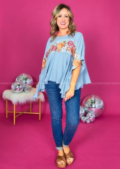 Embracing The Boho Life In My Flowy Floral Blue Top! 🌿💫 #BohoVibes Dusty Blue w/ Rust Embroidery Round Neckline | Mid-length Dolman Sleeves | Split Hemline Soft Denim Feel | Has Stretch | Relaxed Fit Main: 64% Cotton 36% Polyester Contrast: 100% Cotton Measurements Bust Measured Laid Flat Across Front | Armpit to Armpit S/M 25” | M/L 26” Length Measured Shoulder to Hemline S/M 24” | M/L 24” Model: Holly is wearing a S|M Brand: Savanna Jane Blue Denim Tops With Floral Embroidery, Bohemian Embroidered Denim Tops, Light Blue Bohemian Top For Fall, Blue Denim Top For Festivals, Blue Denim Tops For Festival, Blue Denim Festival Top, Blue Floral Print Hippie Top, Hippie Blue Floral Print Tops, Fitted Blue Top With Embroidered Hem