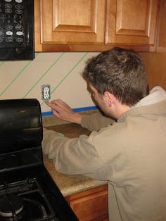 a man is fixing an appliance in the kitchen