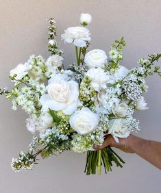 a person holding a bouquet of white flowers