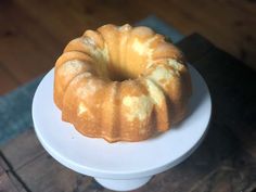 a bundt cake sitting on top of a white plate next to a wooden table