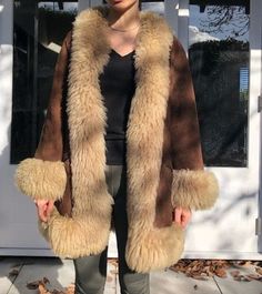 Elevate your wardrobe with our Women's Penny Lane Coat, a luxurious fur coat featuring genuine shearling for unmatched warmth and comfort. This boho hippie-inspired jacket combines vintage 70s charm with modern sophistication. Crafted in a rich brown hue, it boasts authentic sherpa and Afghan coat elements, seamlessly blending wool and real shearling. Perfect for those who appreciate timeless fashion, this suede jacket offers a unique blend of elegance and bohemian flair. Ideal for making a bold Luxury Brown Fur Coat With Fleece Lining, Long Fur Coat With Faux Fur Lining For Fall, Faux Fur Lined Long Coat For Fall, Fall Long Coat With Faux Fur Lining, Brown Faux Fur Lined Outerwear, Brown Shearling Fur Coat With Faux Fur Trim, Brown Sheepskin Outerwear With Faux Fur Trim, Brown Long Coat With Faux Fur Lining, Fall Outerwear With Faux Fur Lining And Sheepskin