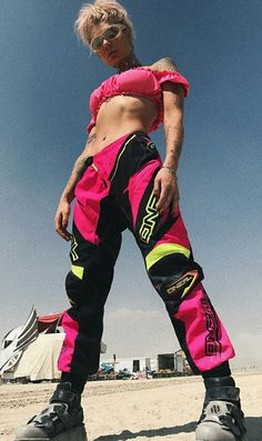 a woman standing on top of a skateboard wearing pink and black pants with neon green accents