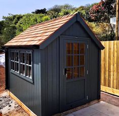 a small shed with a brown roof and windows