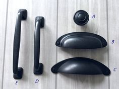 an assortment of door handles and knobs on a wooden surface with numbers below them