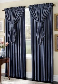 the curtains are open and ready to be hung in front of the window with blue drapes