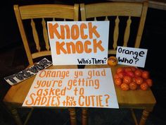 two signs sitting on top of a wooden chair next to oranges and other fruit