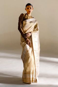 Ivory saree with geometric and floral woven motifs. Comes with unstitched blouse piece.
Component: 2
Pattern: Woven
Fabric: Tissue Silk
Color: Ivory
Other Details: 
Note: Stitched blouse worn by the model is not for sale
Occasion: Wedding - Aza Fashions Festive Cream Pre-draped Saree With Cutdana, Festive Off White Pre-draped Saree, Beige Pre-draped Saree For Festive Occasion, Festive Beige Pre-draped Saree, Traditional Off White Chanderi Pre-draped Saree, Elegant Beige Blouse Piece With Traditional Drape, Elegant Beige Blouse With Traditional Drape, Elegant Cream Blouse Piece For Festive Occasions, Cream Art Silk Saree Set