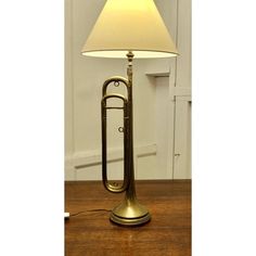 a brass trumpet lamp on a wooden table