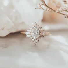 a diamond ring sitting on top of a white flower